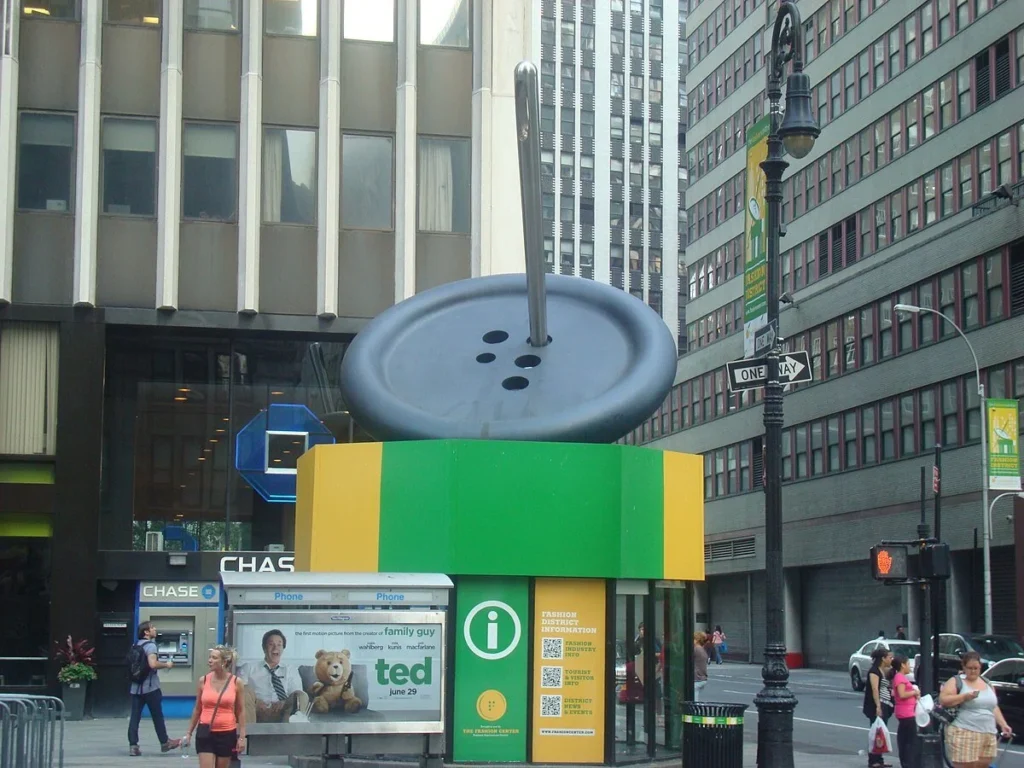 1200px-Garment_District_button_and_needle.jpg