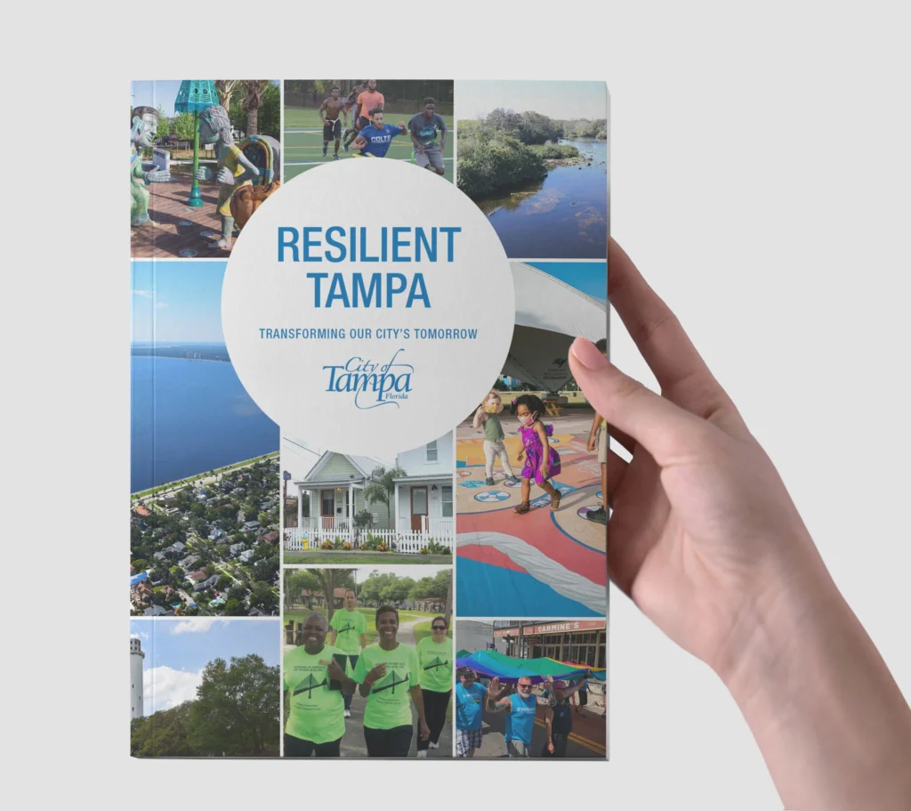 Hand holding the Resilient Tampa printed document